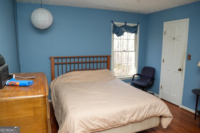 bedroom featuring dark wood-type flooring and a textured ceiling