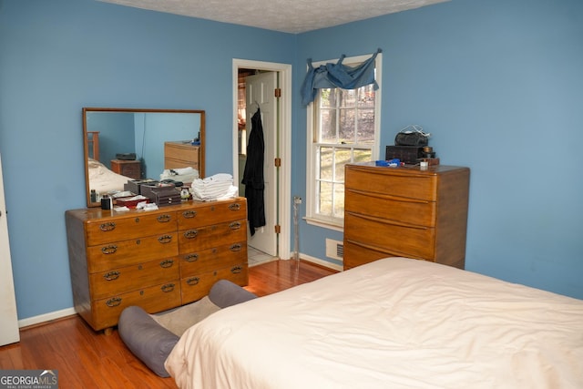 bedroom featuring hardwood / wood-style flooring and a textured ceiling