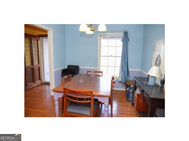 dining space featuring dark hardwood / wood-style floors and a chandelier