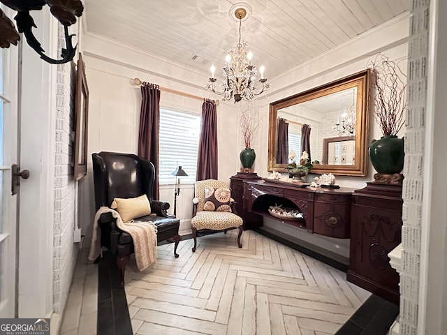 sitting room with ornamental molding, a chandelier, and light parquet floors