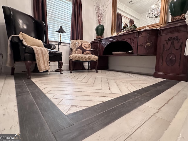 sitting room with a notable chandelier and light parquet flooring