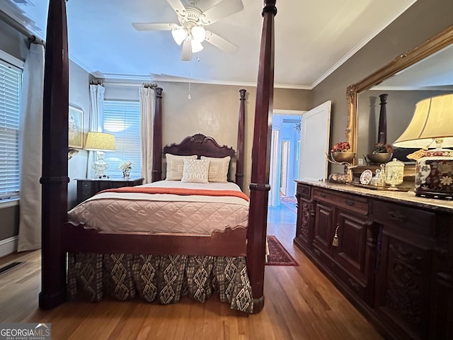 bedroom with ceiling fan, ornamental molding, and hardwood / wood-style floors