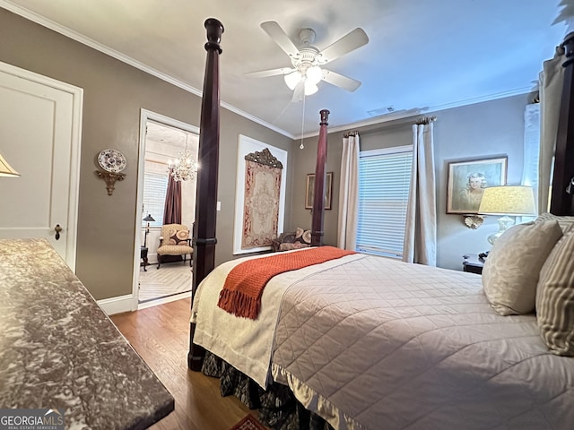 bedroom with hardwood / wood-style flooring, ornamental molding, and ceiling fan with notable chandelier