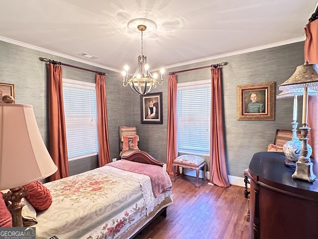 bedroom with hardwood / wood-style flooring, ornamental molding, and a notable chandelier