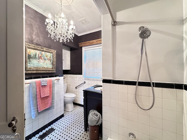 bathroom with tile walls, vanity, walk in shower, toilet, and crown molding