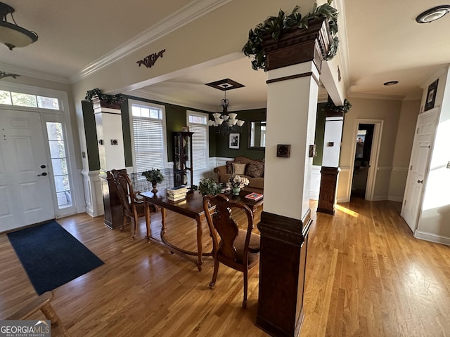 entryway featuring crown molding, light hardwood / wood-style flooring, and a notable chandelier