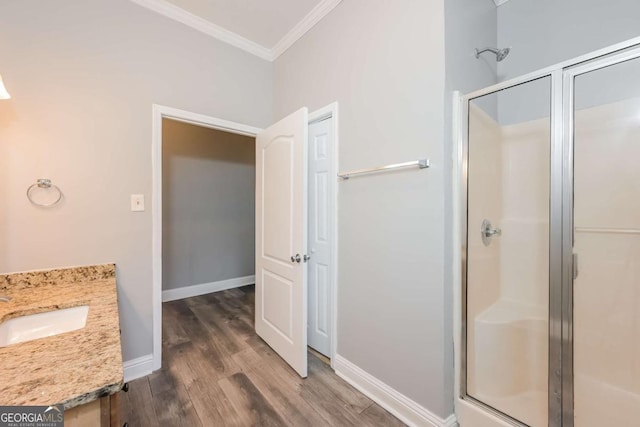 bathroom with vanity, hardwood / wood-style flooring, walk in shower, and ornamental molding