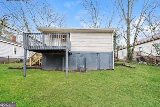 back of property with a lawn and a wooden deck