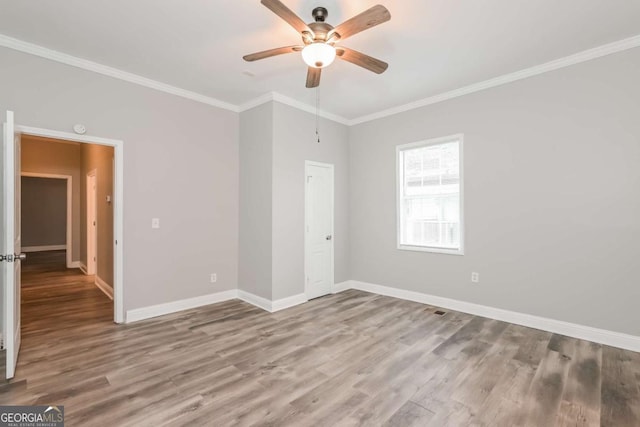 unfurnished room with wood-type flooring, ceiling fan, and ornamental molding