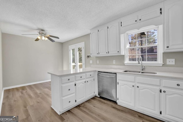 kitchen with white cabinets, sink, stainless steel dishwasher, ceiling fan, and kitchen peninsula