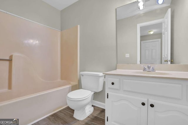 full bathroom with bathtub / shower combination, wood-type flooring, vanity, and toilet