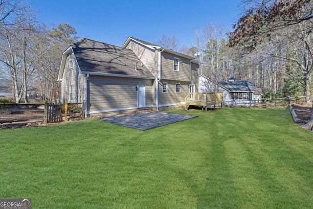 rear view of property with a wooden deck and a lawn