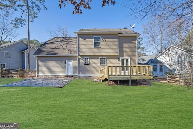 rear view of property featuring crawl space, a lawn, and a deck