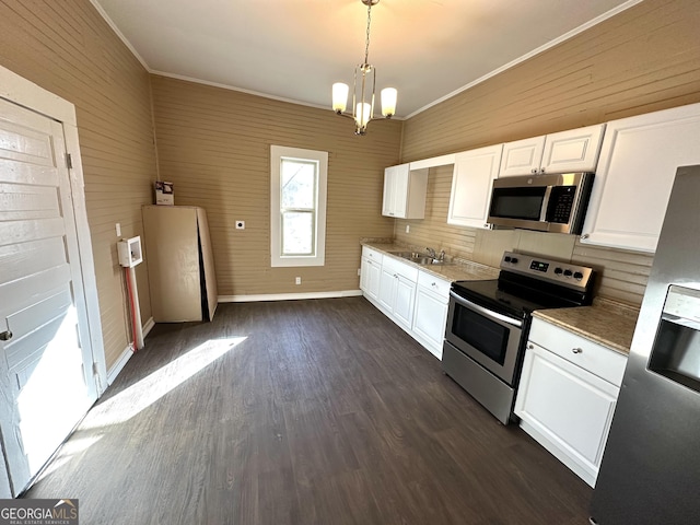 kitchen featuring white cabinets, appliances with stainless steel finishes, decorative light fixtures, and a notable chandelier