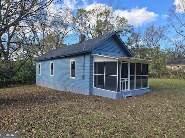 view of side of home featuring a yard and a sunroom