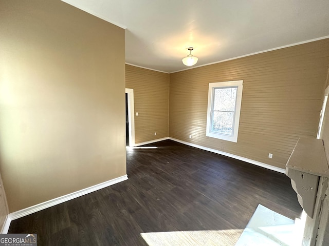 spare room featuring crown molding and dark wood-type flooring