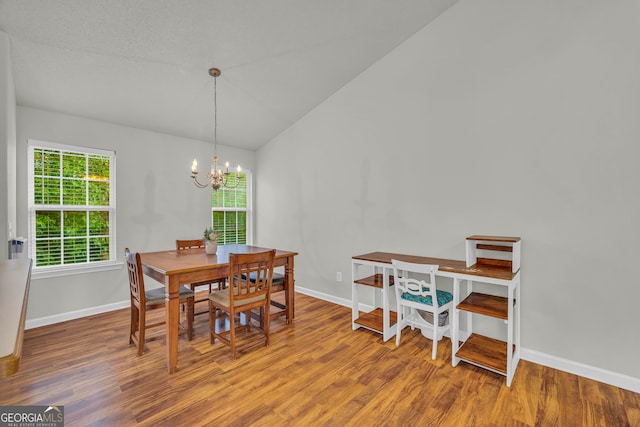 dining area featuring lofted ceiling, wood-type flooring, and a chandelier