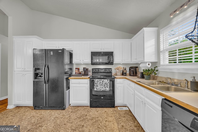 kitchen featuring sink, white cabinets, black appliances, and high vaulted ceiling