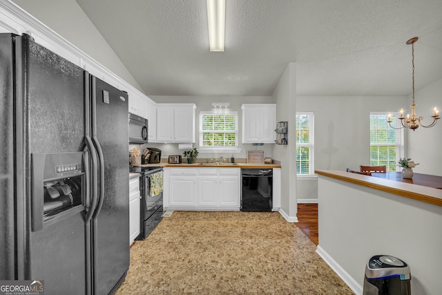 kitchen featuring sink, black appliances, pendant lighting, a chandelier, and white cabinetry