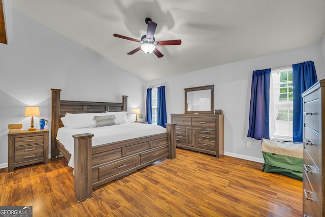 bedroom with ceiling fan, hardwood / wood-style floors, and lofted ceiling