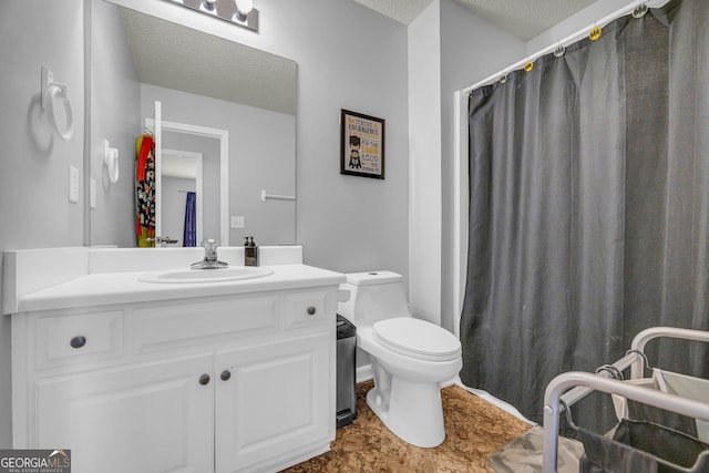 bathroom with vanity, toilet, and a textured ceiling