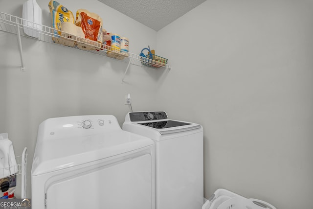 laundry area with a textured ceiling and independent washer and dryer