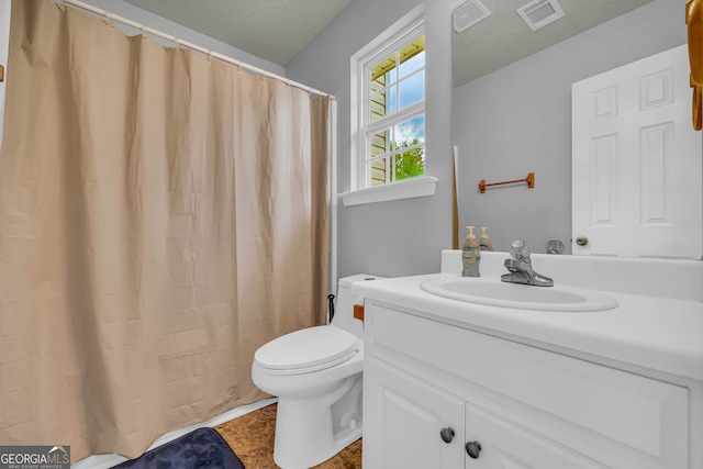 bathroom with vanity, a textured ceiling, and toilet