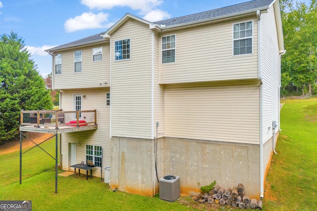 back of property with cooling unit and a lawn