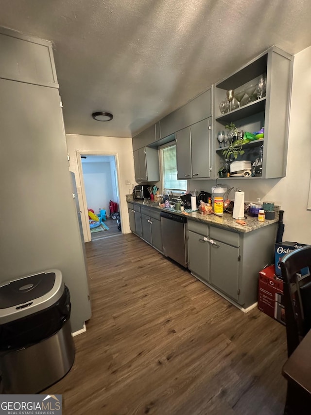 kitchen with a textured ceiling, dishwasher, gray cabinets, and dark wood-type flooring