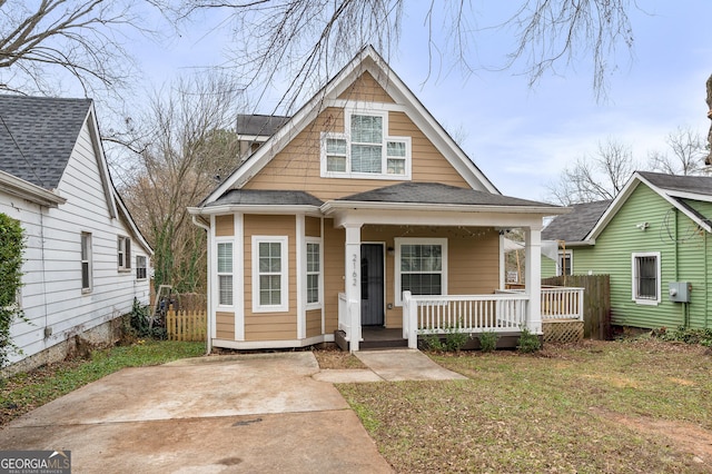 bungalow-style house with a front yard and covered porch