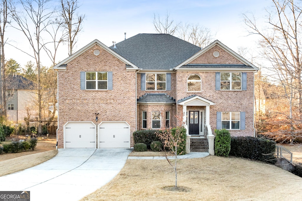 view of front of house with a garage, a shingled roof, concrete driveway, and brick siding