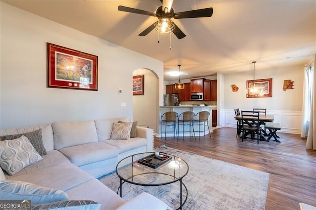 living room featuring ceiling fan and dark hardwood / wood-style floors