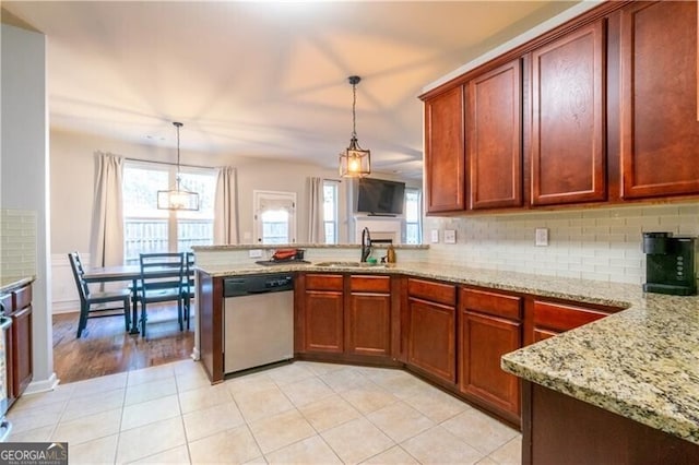 kitchen featuring pendant lighting, dishwasher, decorative backsplash, and sink