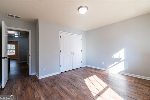 unfurnished bedroom featuring dark hardwood / wood-style floors and a closet