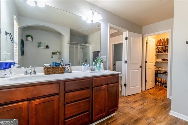 bathroom featuring wood-type flooring, vanity, and a shower with door