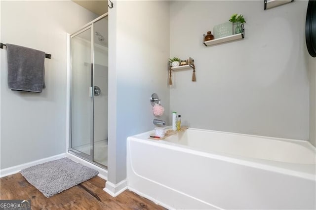 bathroom with plus walk in shower and wood-type flooring