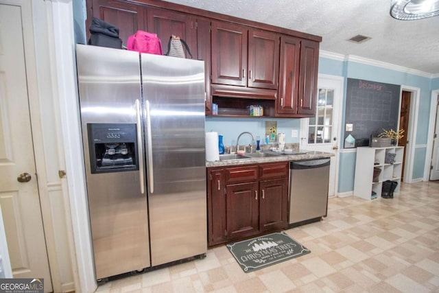 kitchen featuring sink, stainless steel appliances, a textured ceiling, and ornamental molding