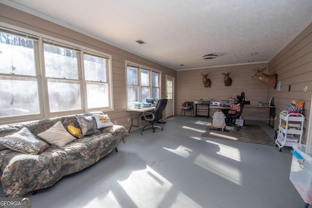 living room with concrete flooring, crown molding, and wooden walls