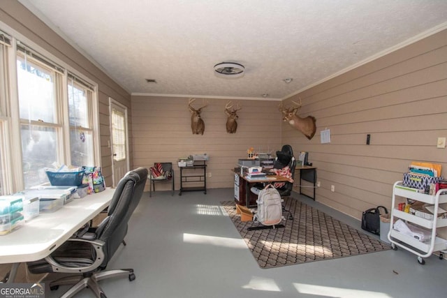 home office featuring a textured ceiling, concrete floors, ornamental molding, and wooden walls