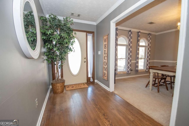 entryway with carpet, a textured ceiling, and crown molding