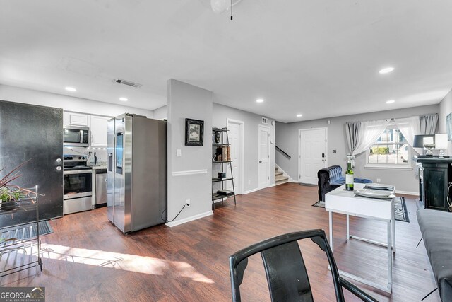 interior space with white cabinetry, dark wood-type flooring, and appliances with stainless steel finishes