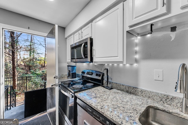 kitchen featuring a healthy amount of sunlight, sink, white cabinetry, and stainless steel appliances