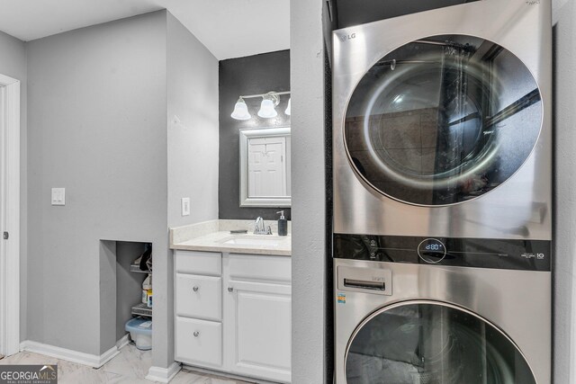 laundry area with stacked washer and dryer and sink