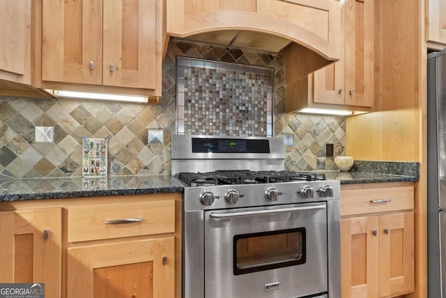 kitchen featuring decorative backsplash, dark stone countertops, appliances with stainless steel finishes, and custom exhaust hood