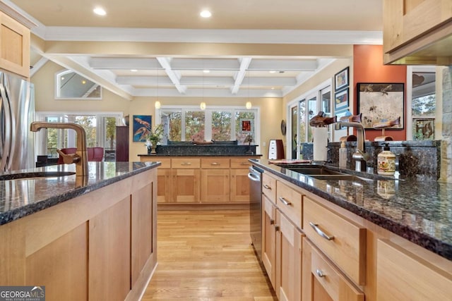 kitchen with appliances with stainless steel finishes, beam ceiling, light hardwood / wood-style flooring, dark stone countertops, and hanging light fixtures