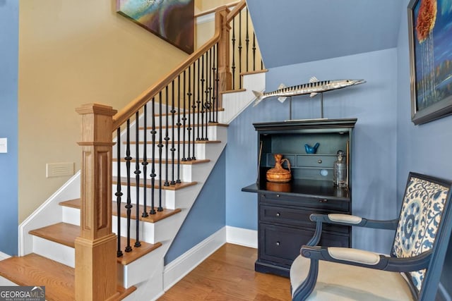 stairway with hardwood / wood-style flooring