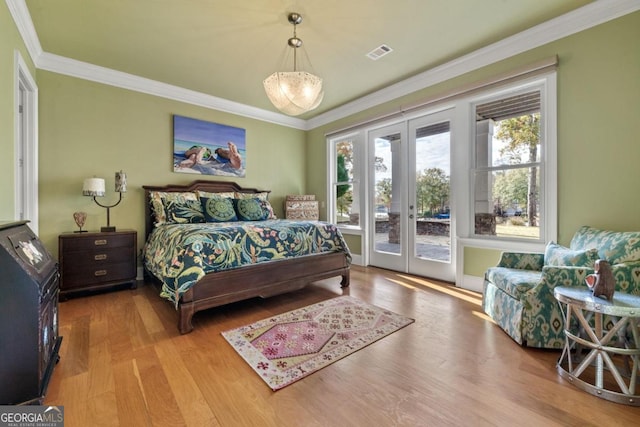 bedroom with light wood-type flooring, crown molding, access to outside, and french doors