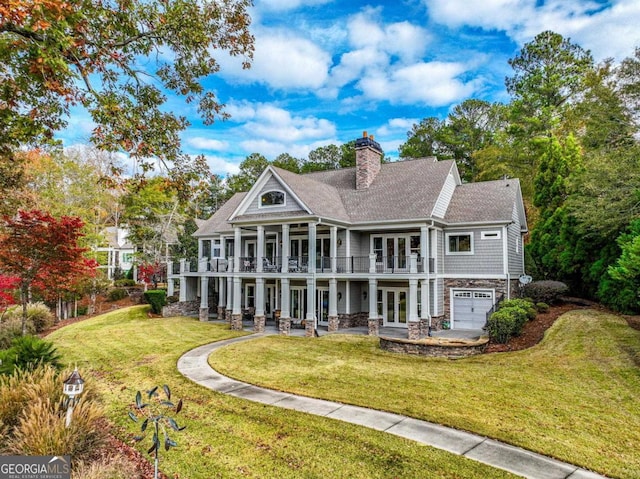 back of house featuring french doors, a balcony, a patio area, a yard, and a garage