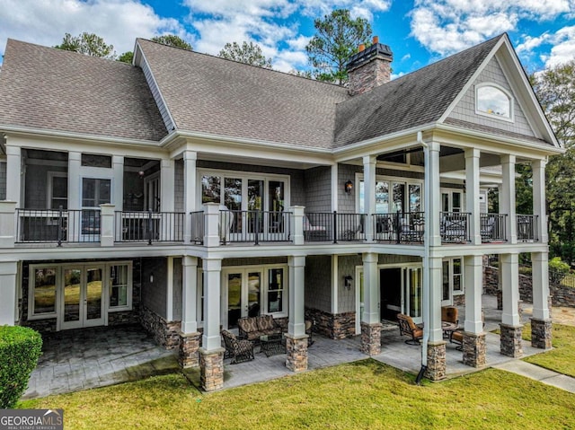 rear view of property featuring a balcony, an outdoor hangout area, a patio, and french doors