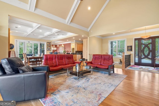 living room featuring beamed ceiling, plenty of natural light, light hardwood / wood-style floors, and ornamental molding